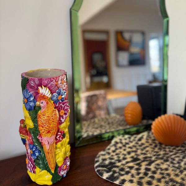 Vase en céramique coloré décoré d’un perroquet et de fleurs tropicales en relief.